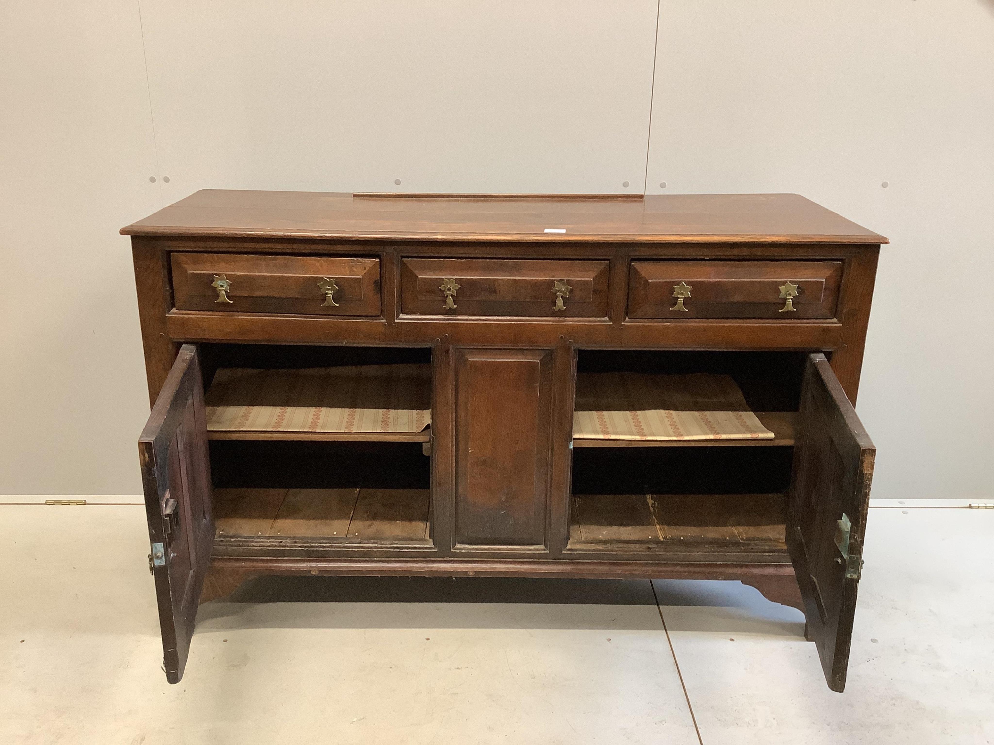 A mid 18th century oak dresser, with fielded panelled cupboards and drawers, width 143cm, depth 49cm, height 89cm. Condition - poor